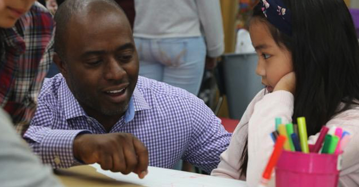 State Superintendent of Public Instruction Tony Thurmond talks to a young student. Photo courtesy of California Black Media.