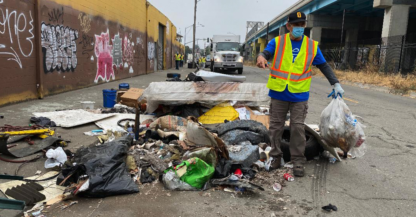 “East and West Oakland are in a state of emergency,” and need resources from the city, said Councilmember Noel Gallo, who is shown here cleaning up illegal dumping during one of his weekly cleanups in District 5, which he represents. Photo courtesy of Noel Gallo’s office.