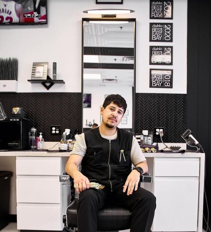 Drew DeGuzman poses in front of his workstation. Photo courtesy of Empire Barbershop.