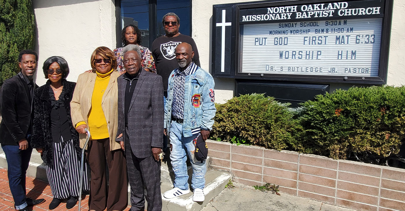 Family and members gather outside North Oakland Missionary Baptist Church. Front row, from left to right: Timothy Rutledge. Jr., grandson of Pastor Sylvester Rutledge; his daughter, J.M. Hale; First Lady Audrey Golden Rutledge, and Pastor Rutledge. Back row from left to right: church members Chavonne Robinson, Clarence Wells of the Golden Light Ministries feeding program, and the pastor's son Timothy Rutledge, Sr. Photo by Carla Thomas.