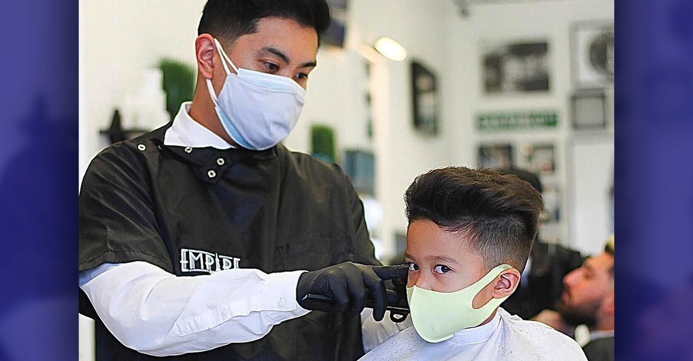 Drew DeGuzman cuts a child’s hair. Photo courtesy of Empire Barbershop.