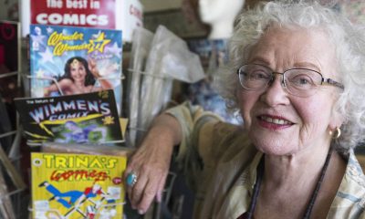 Trina Robbins, the first woman to draw Wonder Woman, with some examples of her cartoon art. (Photo credit: Jessica Christianson)