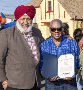 Joe Fisher, right, accepts a commendation from Harpreet Sandhu, who works in the office of Congressman John Garamendi. Photo by Don Gosney.