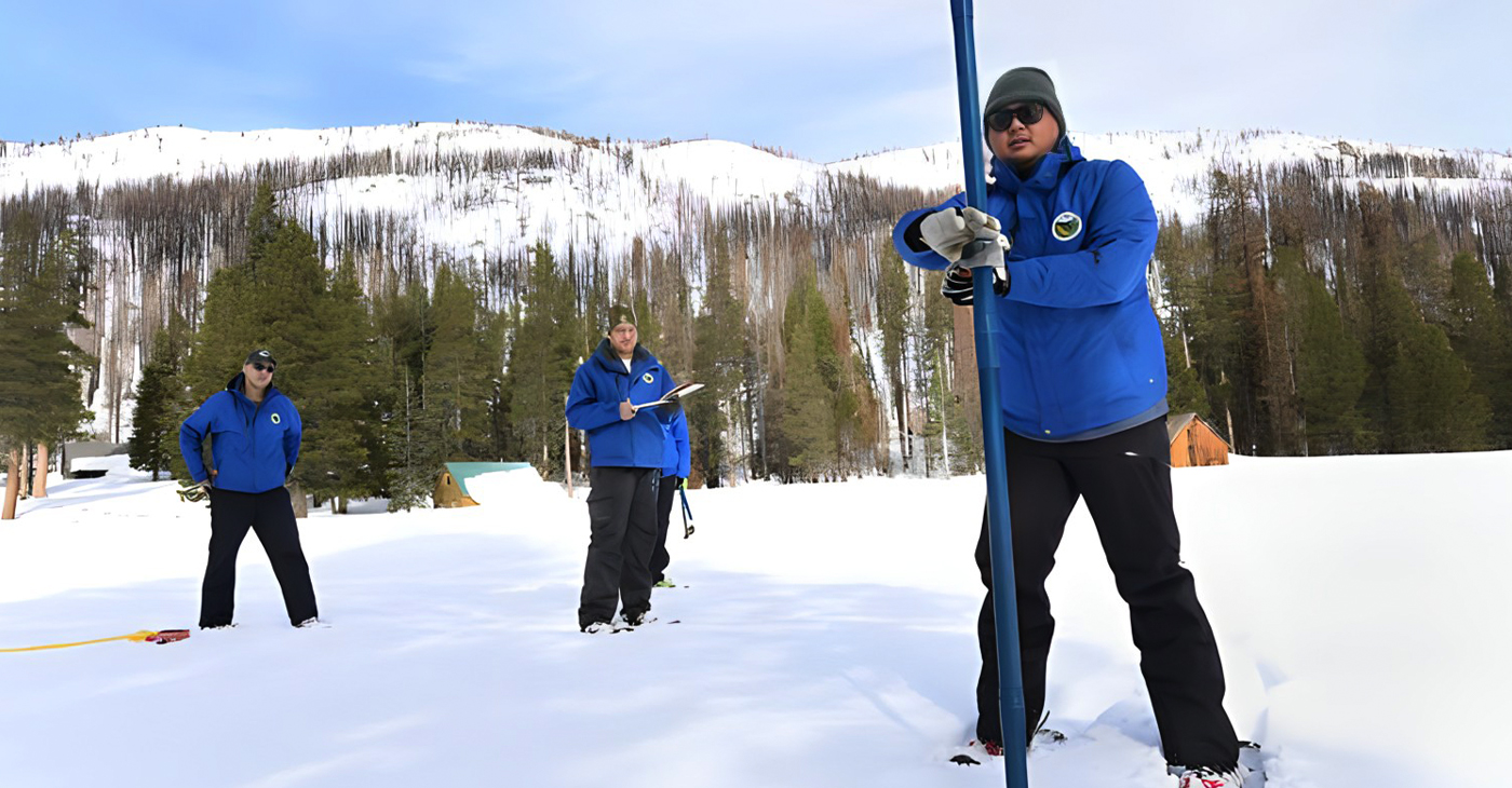 (R) Sean de Guzman, Manager of the California Department of Water Resources Snow Surveys and Water Supply Forecasting Unit, inserts the long aluminum pole into the deep snow. (L) Jordan Thoennes, Water Resources Engineer in Snow Surveys and Water Supply Forecasting Unit, and (C) Jacob Kollen, Water Resources Engineer in Snow Surveys and Water Supply Forecasting Unit, measure the snowpack during the fourth media snow survey of the 2023 season at Phillips Station in the Sierra Nevada April 3, 2023. The survey is held approximately 90 miles east of Sacramento, Calif., off U.S. Highway 50 in El Dorado County. (Kenneth James/California Department of Water Resources via Bay City News)