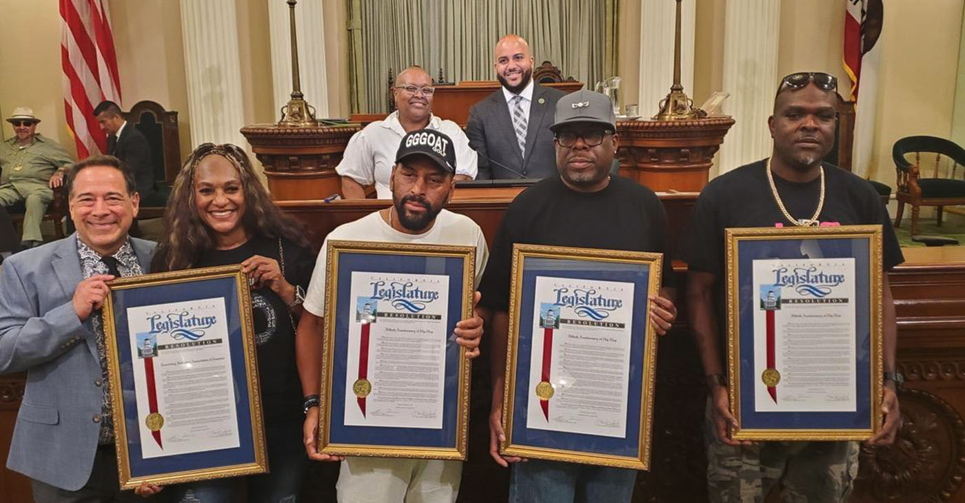 Caption: Pictured from left to right on the California Assembly floor with framed resolutions are Joel Flatow (senior VP of Recording Industry Association of America’s West Coast Operations); Juana Burns-Sperling (co-founder of JJ Fad), Kim Renard Nazel (Arabian Prince), Roger McBride (King T), and Jon Owens (Casual from Oakland-based Hieroglyphics). Aug. 14, 2023. CBM Photo by Antonio Ray Harvey.