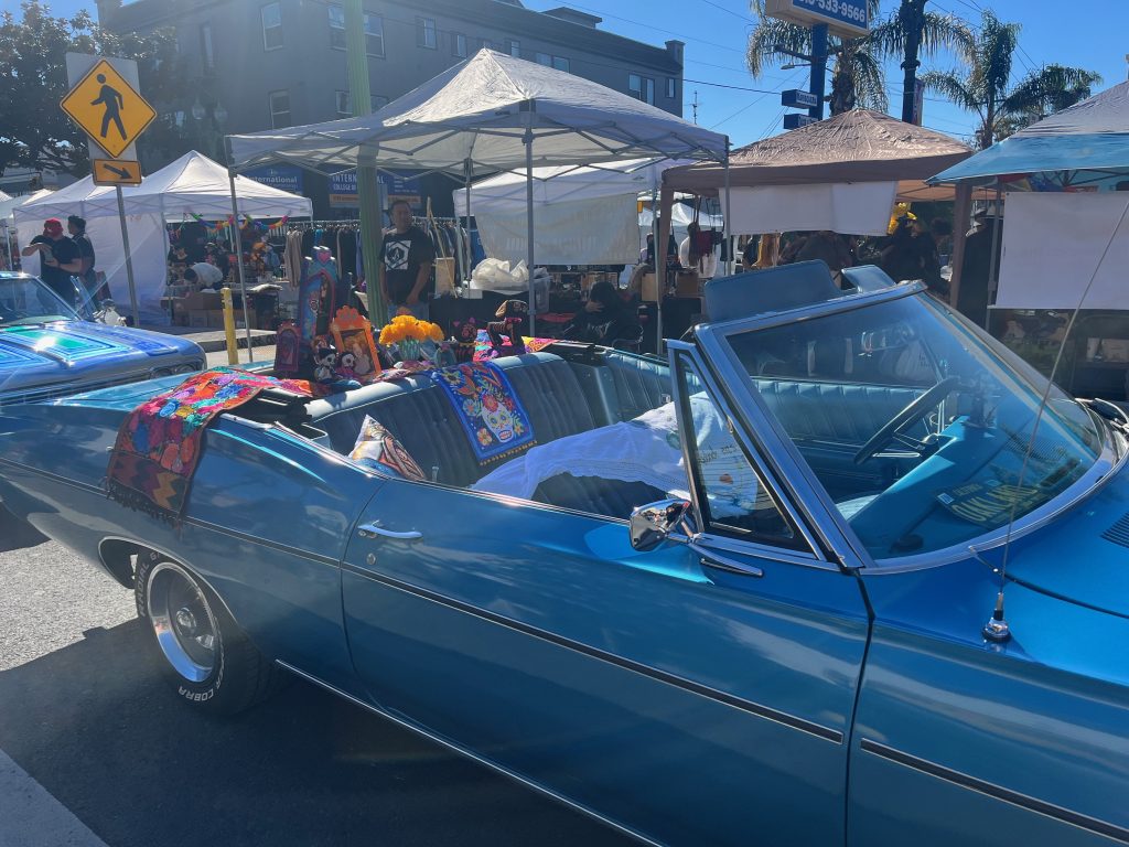 A vintage car becomes the site for an ofrenda at “Blooming Resistance,” the Unity Council’s 28th Día de los Muertos Festival on Oct. 29, 2023. Photo by Magaly Muñoz.