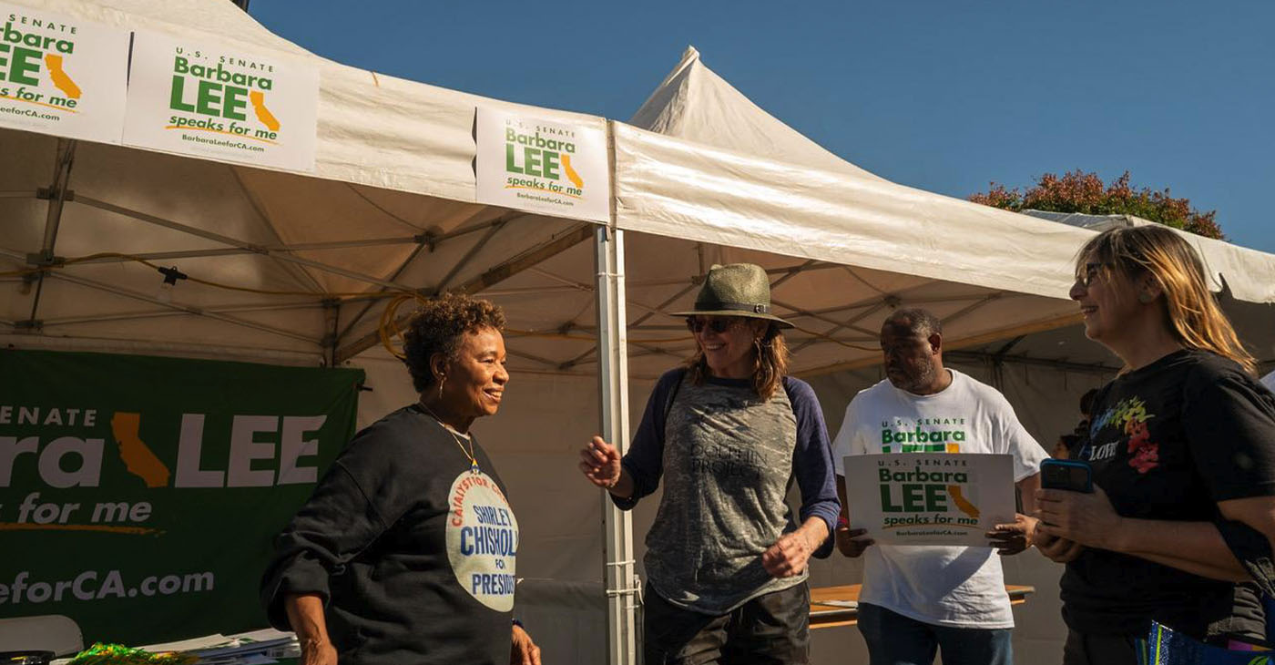Wearing a sweatshirt honoring her mentor, the late Shirley Chisholm, U.S. Senate Candidate Barbara Lee engages with Taste of Soul attendees at her booth on Sunday. Photo by Maxim Elramsisy, California Black Media.