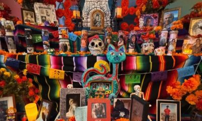 A community altar including framed photos of the deceased among marigolds and candles at the Oakland Museum on Oct. 22, 2023. Photo by Eva Ortega
