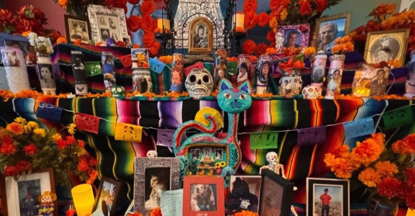 A community altar including framed photos of the deceased among marigolds and candles at the Oakland Museum on Oct. 22, 2023. Photo by Eva Ortega