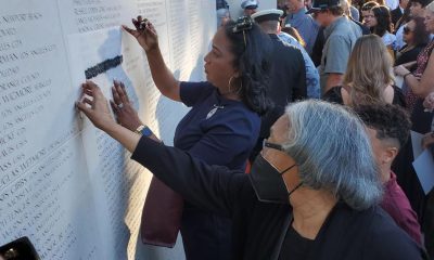 The family of Ronald Yale Wiley visits the California Firefighters Memorial Wall to trace his name engraved on the monument. Wiley, who died in the line of duty in 2007, was a deputy marshal for Richmond’s Fire Department. Photo by Antonio Ray Harvey.