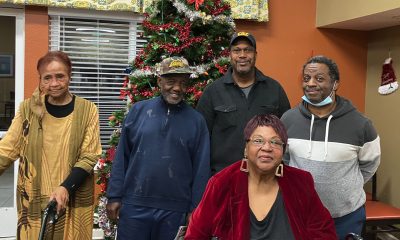 Left to right: Dolores Ferrell, Donald Roberts, Samuel Lewis, Elda Fontano, and Timothy Sykes stand in front of a Christmas Tree at Heritage Park at Hilltop Affordable Senior Apartments in Richmond on Dec. 12. Photo by Zack Haber.