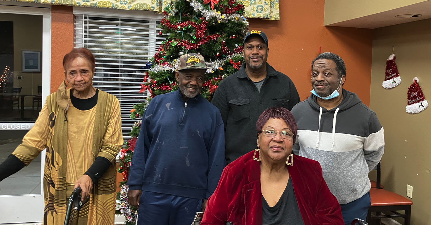 Left to right: Dolores Ferrell, Donald Roberts, Samuel Lewis, Elda Fontano, and Timothy Sykes stand in front of a Christmas Tree at Heritage Park at Hilltop Affordable Senior Apartments in Richmond on Dec. 12. Photo by Zack Haber.