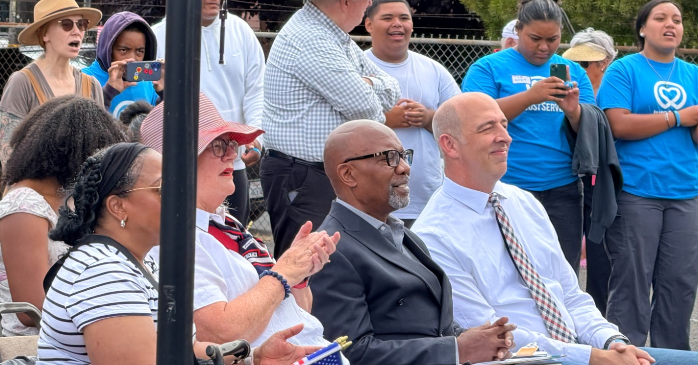 Pastor Michael Wallace of Mt. Zion Missionary Baptist Church (center) and David Kimball, president of the Oakland Stake of the LDS church listen to remarks before volunteers began their work. “We are grateful to partner with these organizations to help care for those in need in our community,” Kimball later told the assembled volunteers. Courtesy photo.