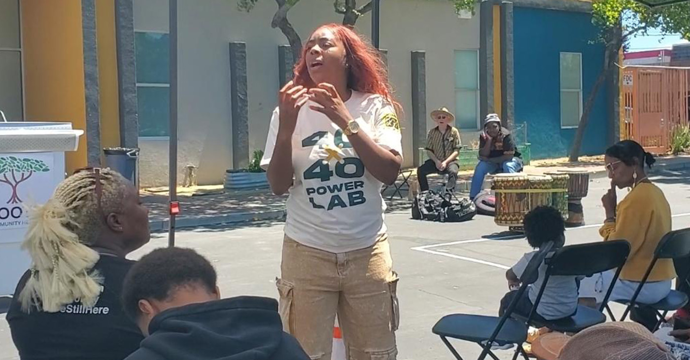 Khariyyah Shabazz, associate director of Neighborhood Development with Roots Community Health, addresses community members about Peace Committees at Lodestar Academy in East Oakland. Photo By Carla Thomas.