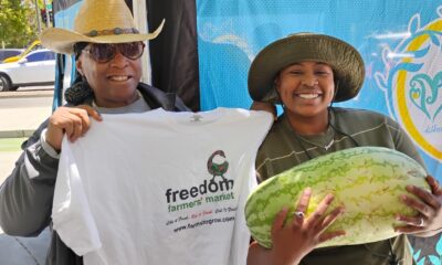Elaine Smith, executive director of Farms to Grow, Inc., holds T-shirt for Ki’Ara LaFitte, winner of the Freedom Farmers’ Market Watermelon-Eating Contest at the season opening on July 11. Courtesy photo.