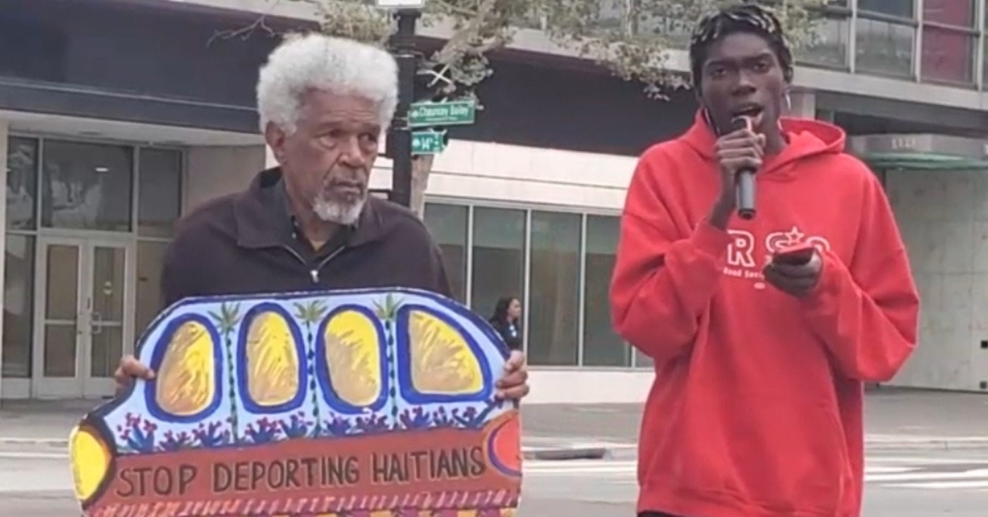 Activists Gerald Smith and Romaine Charite at 14th and Broadway in downtown Oakland near City Hall protest in support of Haitian immigrant rights. Photo by Carla Thomas