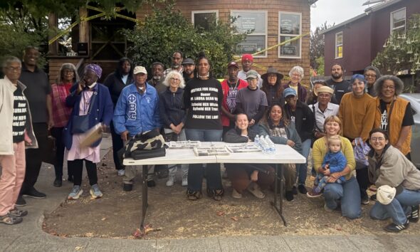 Zakiya Jendayi, center, surrounded by supporters at the weekly gathering at her house to halt her eviction. Photo by Tanya Dennis.